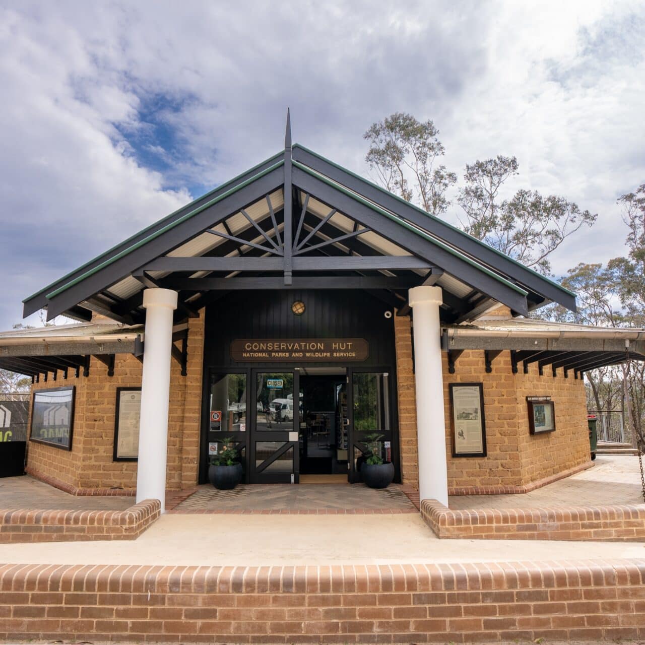 Brick building with an arched entrance labeled "Conservation Hut"
