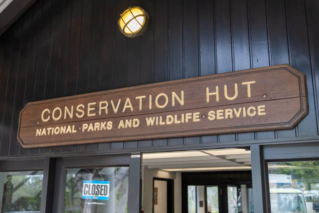 A wooden sign above a door that reads "Conservation Hut"