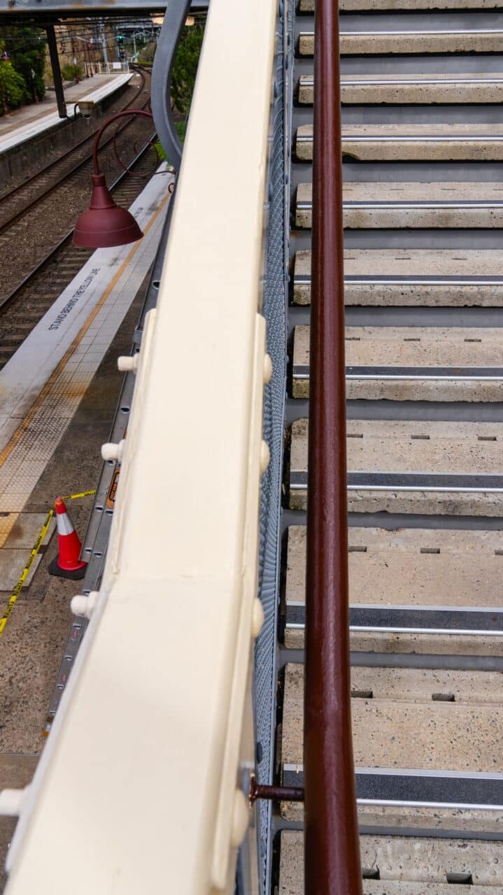 A staircase beside the Mt Vic Train Station platform featuring beige handrails
