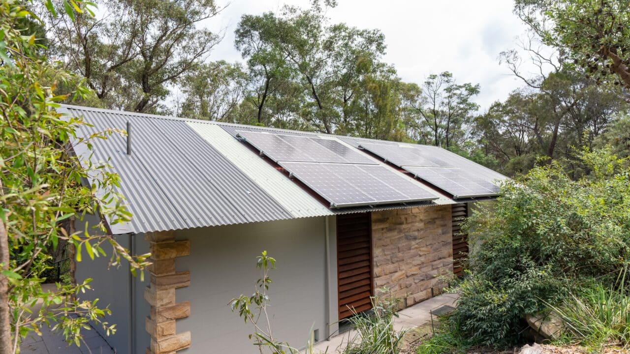 A small house in Wentworth Falls with a corrugated metal roof and solar panels