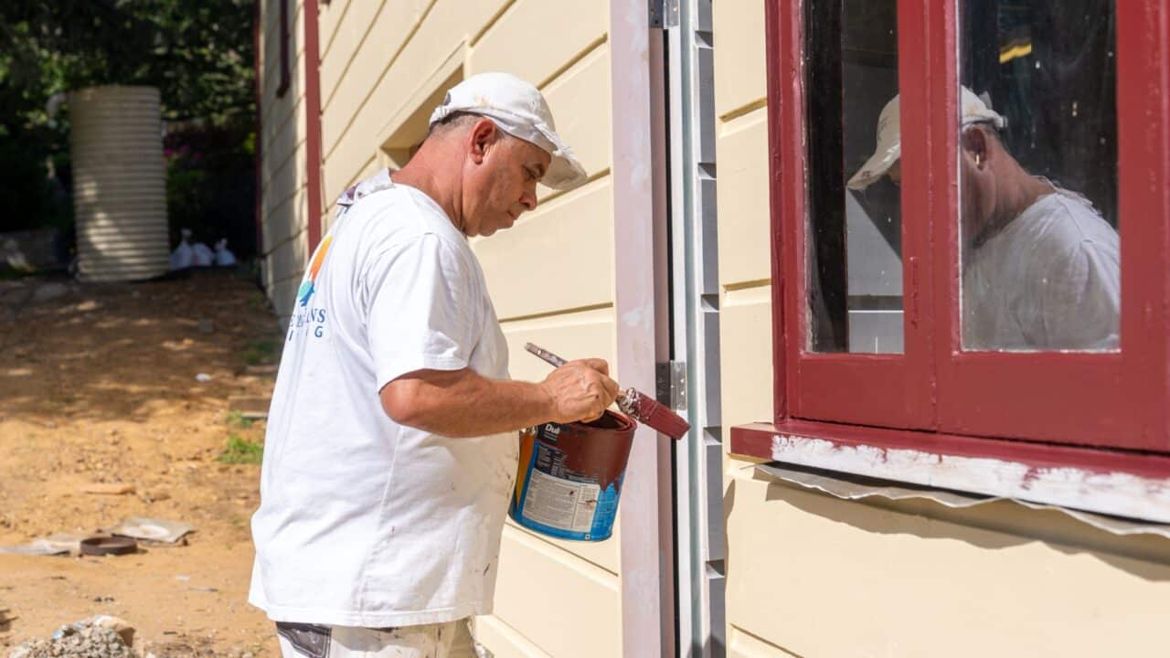 A person from Blue Mountains Painting team painting the edges of a window frame