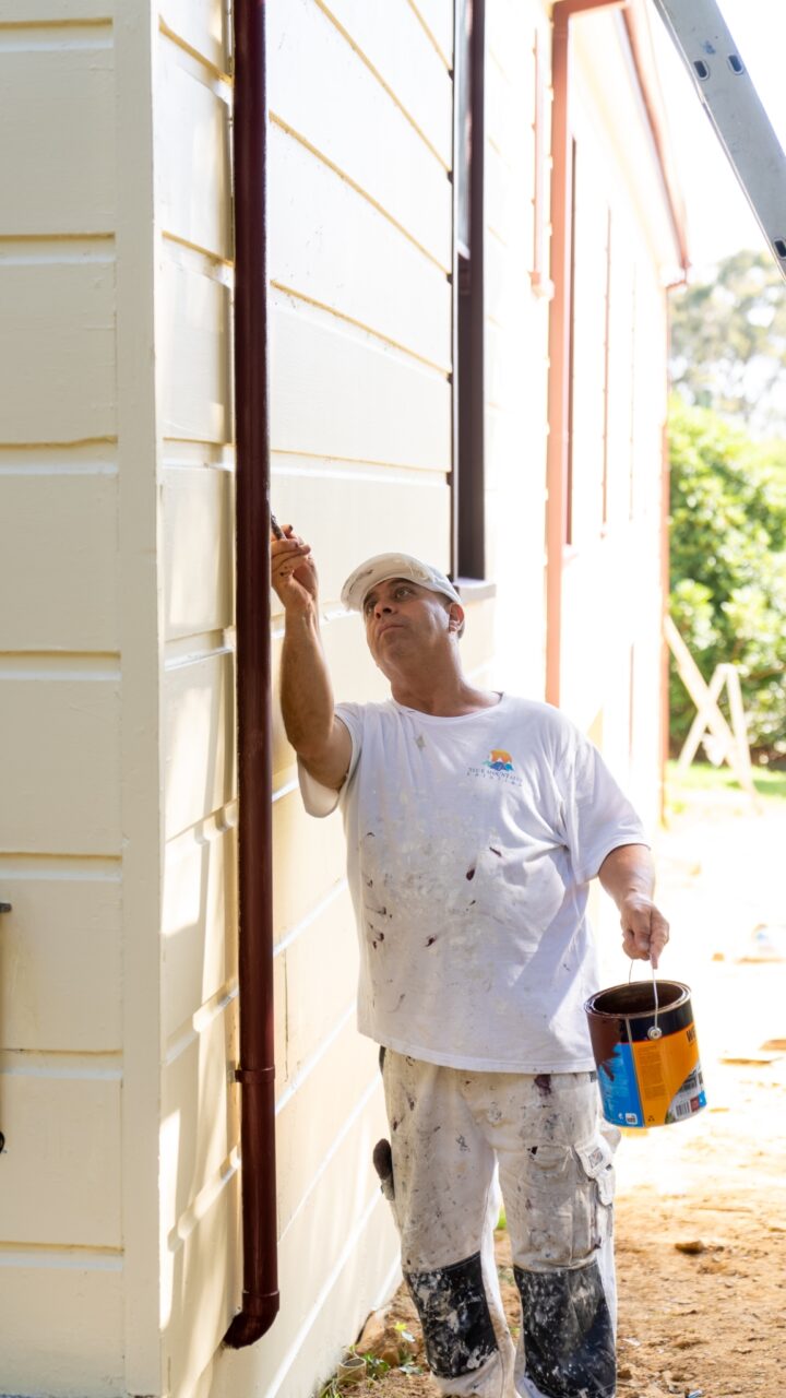 Man in a white, blue mountains painting shirt, representing Residential Painting Services