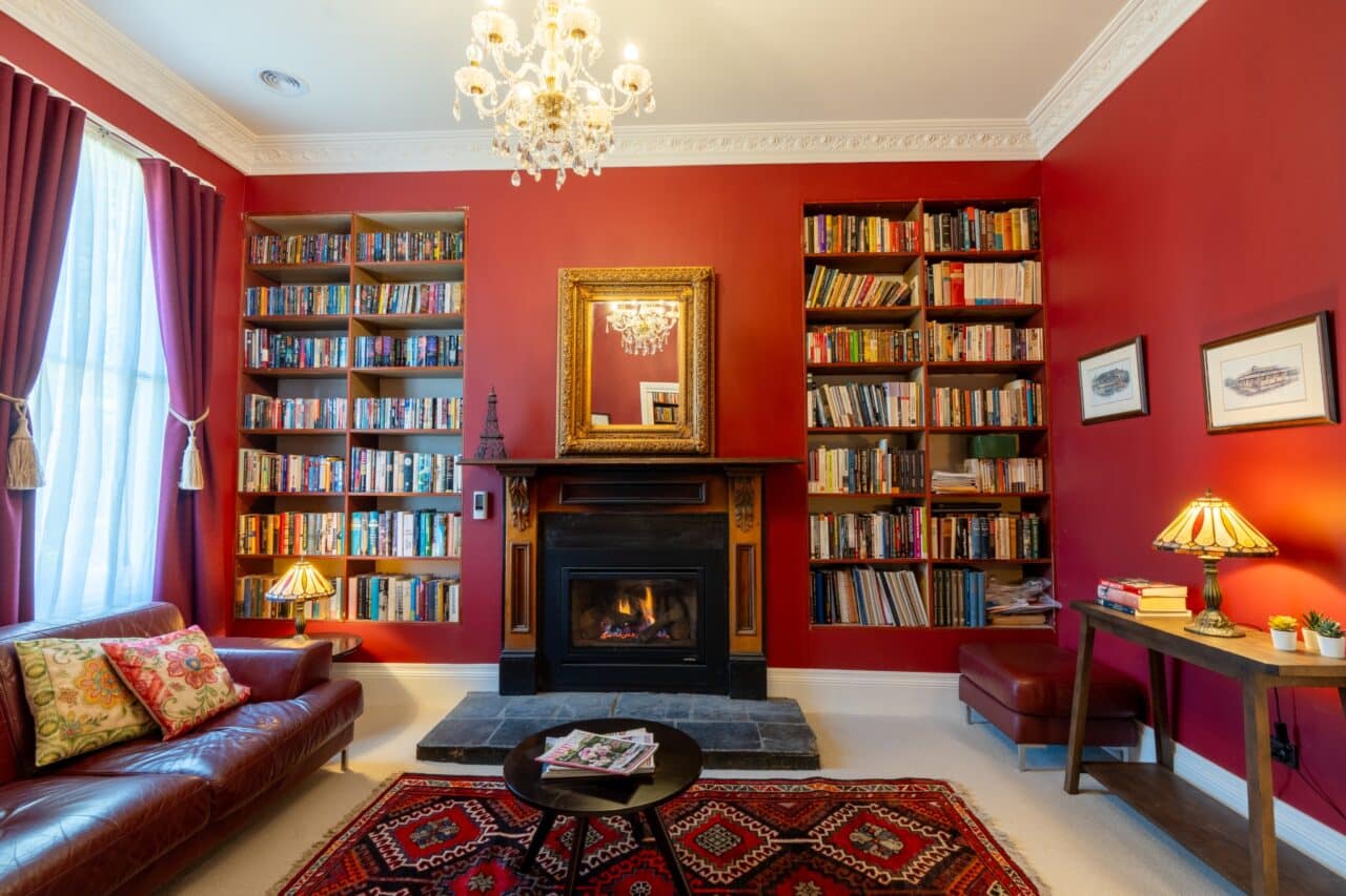 A living room with red walls, painted to perfection by Interior Painting Services