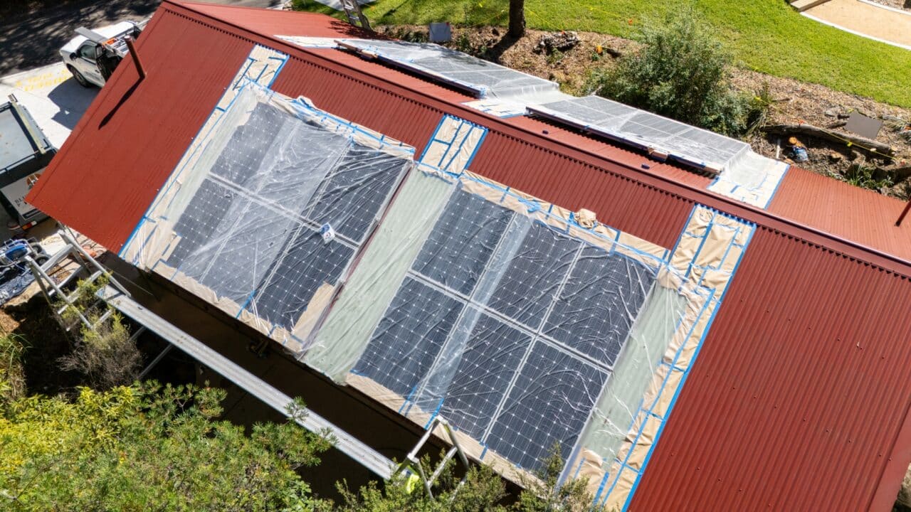 Aerial view of a red rooftop with partially installed solar panels