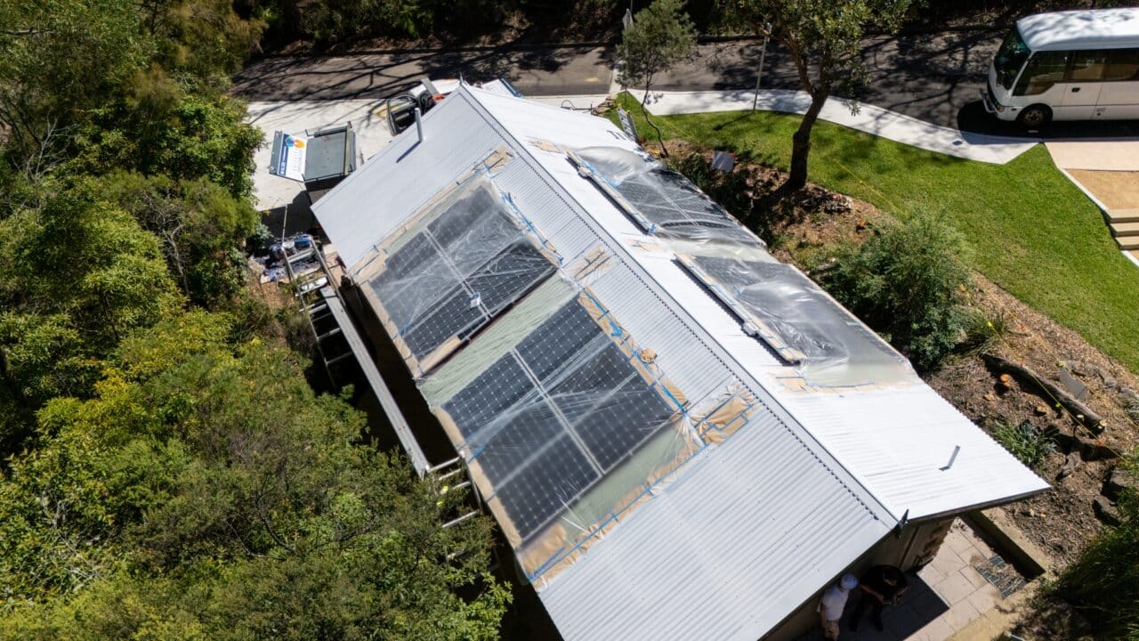 Aerial view of a house with solar panels installed on the roof
