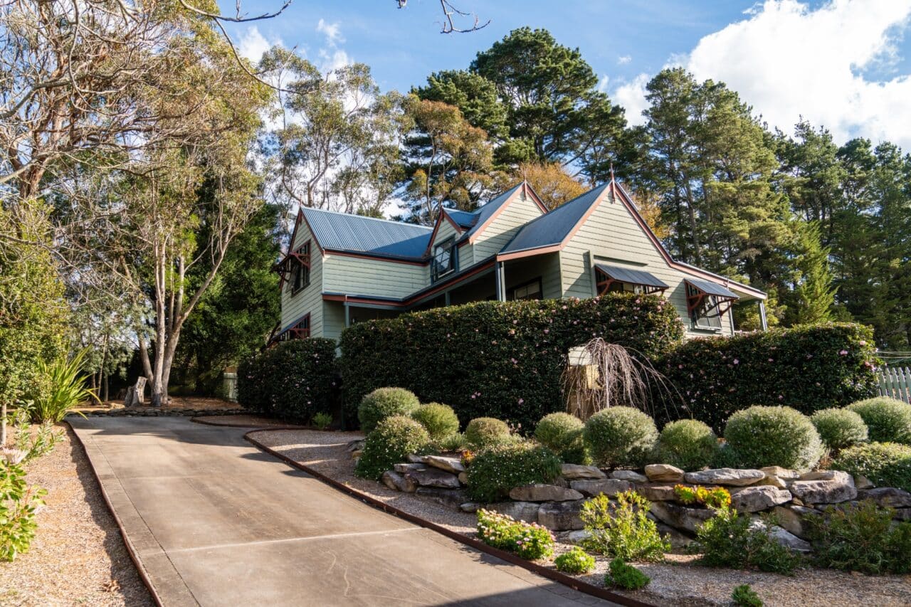 Charming bullaburra house and a two-story home with a gray roof and green exterior.