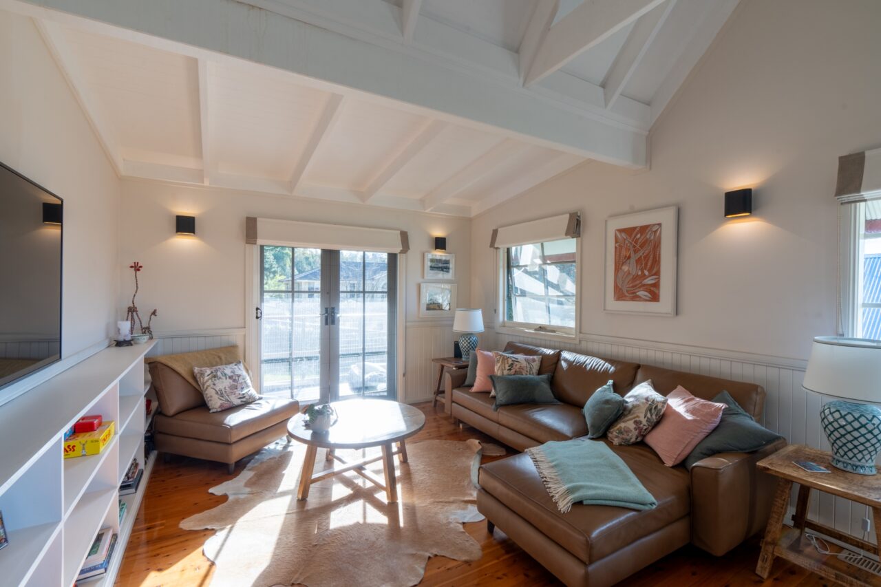 Bullaburra house living room featuring leather sofas and a round coffee table.