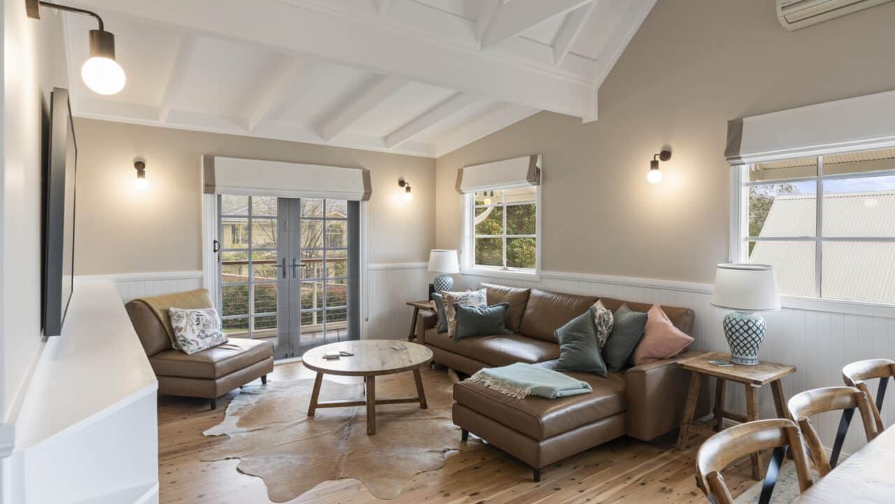 a cozy living room at bullaburra house featuring a leather sofa adorned with pillows
