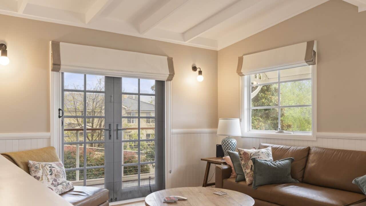 a cozy living room at bullaburra house with a sofa and round wooden table