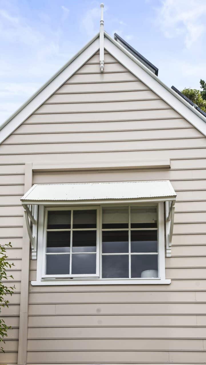a bullaburra house's beige exterior, featuring horizontal siding and a window with small awning