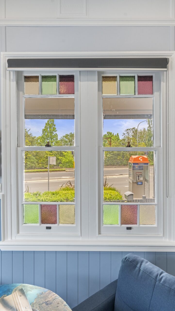 a window with colorful stained glass panes in bullaburra house overlooking a street