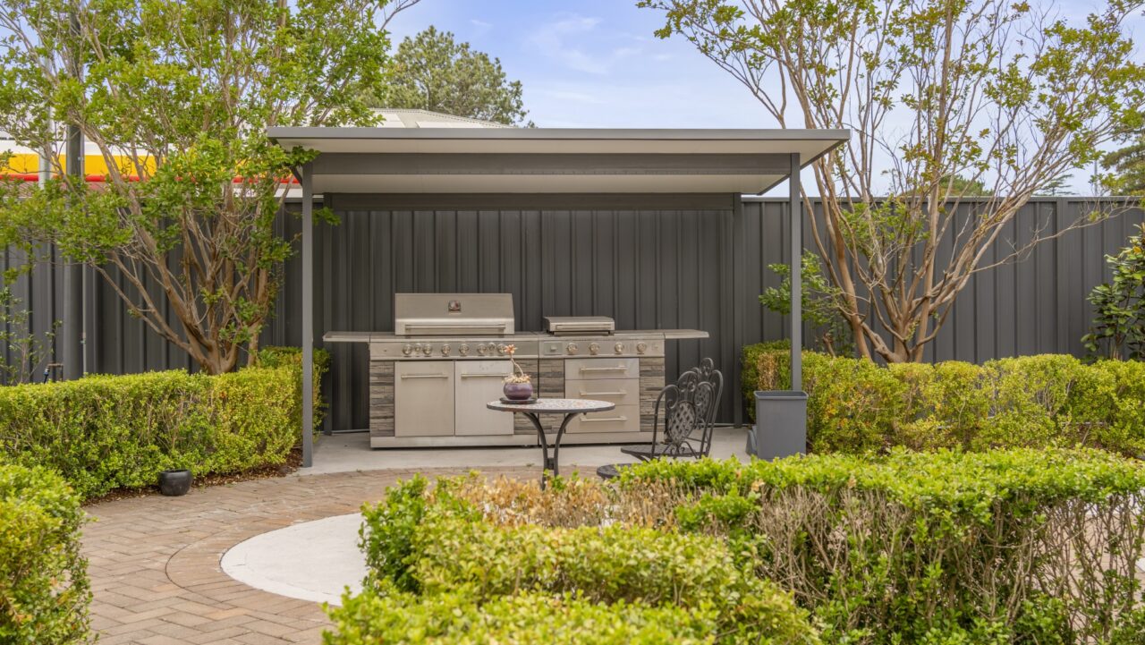 bullaburra house boasting an outdoor kitchen with a sleek metal grill under a canopy
