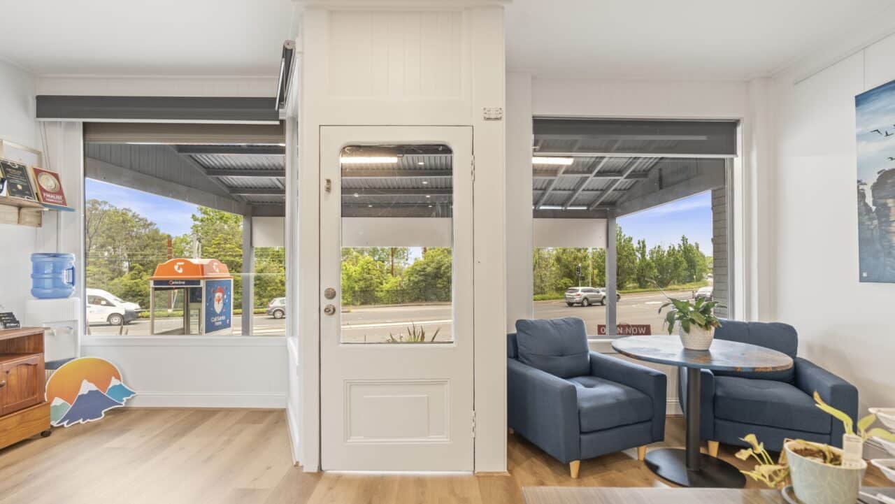 the interior of the cozy bullaburra house featuring two blue chairs and a round table