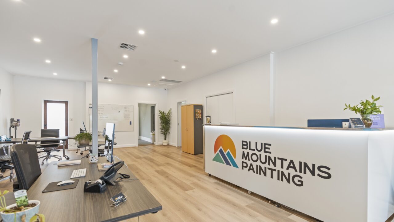 a modern office interior with a reception desk displaying "blue mountains painting"
